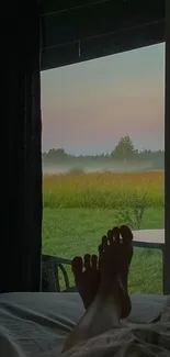 Cozy bedroom view with sunset and misty field for serene mobile wallpaper.