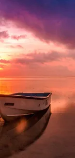 Small boat on serene water reflecting a colorful sunset sky.