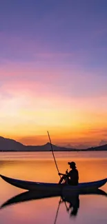 Silhouette of a man fishing on a calm lake at sunset in vibrant colors.