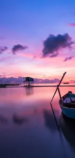 Tranquil sunset over lake with boat, vibrant pink and purple sky.