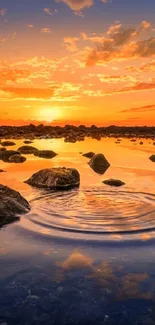 Serene sunset reflecting over a tranquil lake with rocks and evening sky.