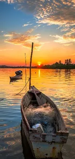 A serene sunset over a peaceful lake with boats, reflecting vibrant orange hues.