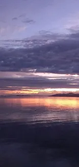 Tranquil sunset over ocean with purple skies and serene reflection.