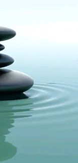 Balanced zen stones on rippling aqua water.