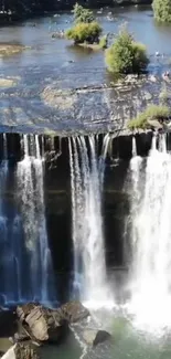 Serene waterfall flowing into a calm river surrounded by lush greenery.