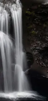 Serene waterfall cascading down rocks in a tranquil nature setting.