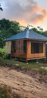 Rustic wooden cabin amidst trees at sunset.