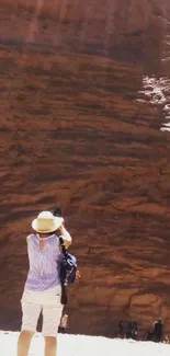 Traveler photographs a vast sandstone canyon.