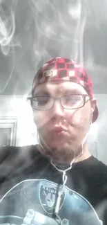 Man wearing a red checkered cap, glasses, and headphones.