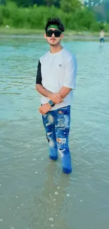 Young man in trendy fashion standing in water.