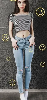 Woman in striped top and jeans with smileys on wallpaper.