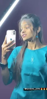 Trendy mirror selfie with teal outfit and modern smartphone.