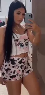 Woman taking a mirror selfie in pajamas.