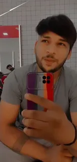 Trendy mirror selfie with colorful phone case in modern setting.