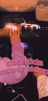 Night drive wallpaper with neon text 'cool kids never sleep' in a car setting.