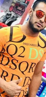 Man in trendy orange t-shirt with sunglasses in a store.