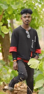 Stylish young man in nature with green leaves.