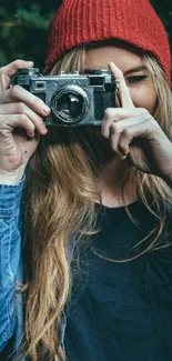 Person with camera wearing red beanie and denim jacket.