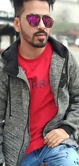 Fashionable man in red shirt and sunglasses, urban setting.