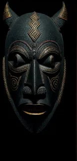 Intricate tribal mask design on black background.