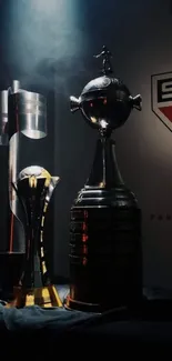 Illuminated football trophies on display in a dimly lit setting.