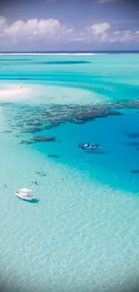 Aerial view of a turquoise tropical beach with lush greenery and clear skies.