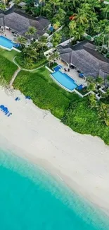 Aerial view of tropical beach with villas and turquoise ocean.