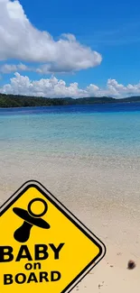 Tropical beach with baby on board sign, clear sky and ocean.