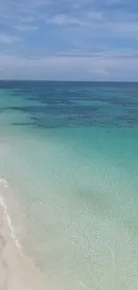 Serene tropical beach with turquoise waters and soft sandy shore under a clear sky.