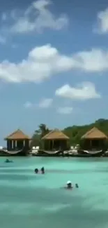 Tropical beach with turquoise water and overwater bungalows.