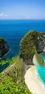 Tropical beach with clear blue ocean and lush green cliffs.