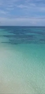 Turquoise waters at a tropical beach with clear sky and calm waves.