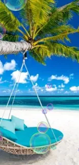 Tranquil tropical beach with hammock under palm tree in bright blue sky.