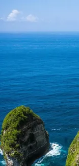 Scenic tropical beach with blue ocean and lush cliffs.