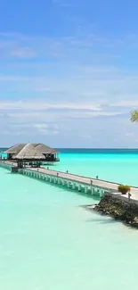 Tropical beach with turquoise water and wooden pier.