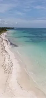 Tropical beach with clear turquoise water and sandy shore.