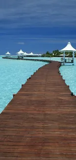 Tropical pier leading into azure waters under a vivid blue sky.