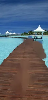 Tropical beach pier with turquoise waters and sunny skies.