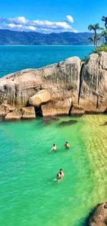 Scenic tropical beach with turquoise water and rocky shoreline.