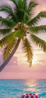 Palm tree at beach during sunset with pink sky and ocean.