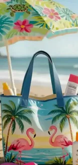 Tropical beach with flamingo bag and umbrella on sand.