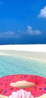 Pink donut float on turquoise beach water under a clear blue sky.