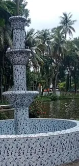 Tropical garden with stone fountain and lush foliage.