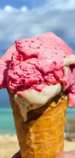 Pink ice cream cone on a tropical beach background.