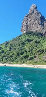 Tropical island with lush green hills and clear blue waters under a bright sky.