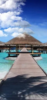 Tropical island view with huts and turquoise water under blue sky.