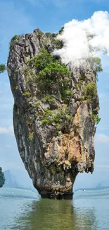 Tropical island with towering rock formation and calm waters.