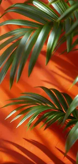 Tropical green leaves on vivid orange background.