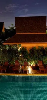 Peaceful tropical pool at night with warm lighting and lush surroundings.