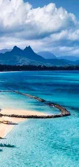 Stunning tropical beach with blue waters and lush mountains viewed from above.